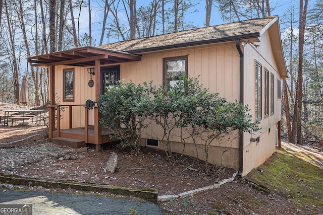 view of front of home featuring roof with shingles and crawl space