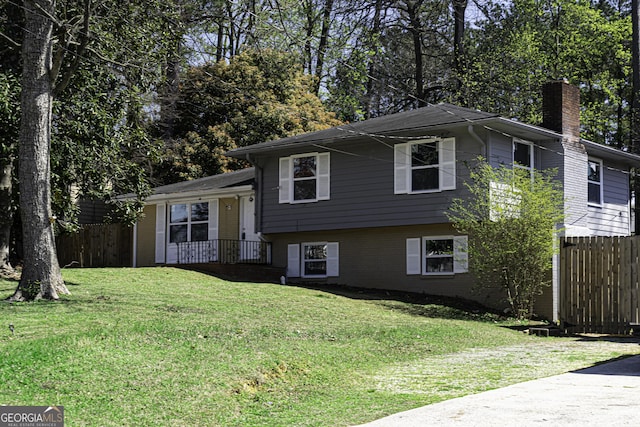 2666 Frontier Trl, Atlanta, GA 30341 - split level home with brick siding, a chimney, a front lawn, and fence