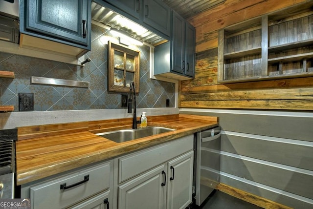 kitchen with butcher block countertops, a sink, and tasteful backsplash