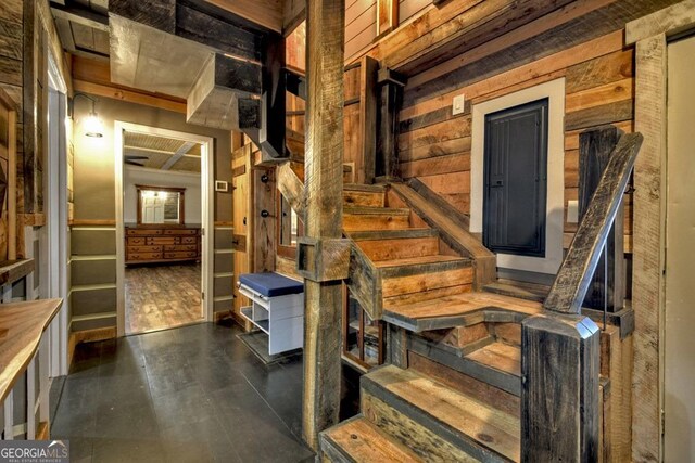 stairway featuring wooden walls and wood finished floors