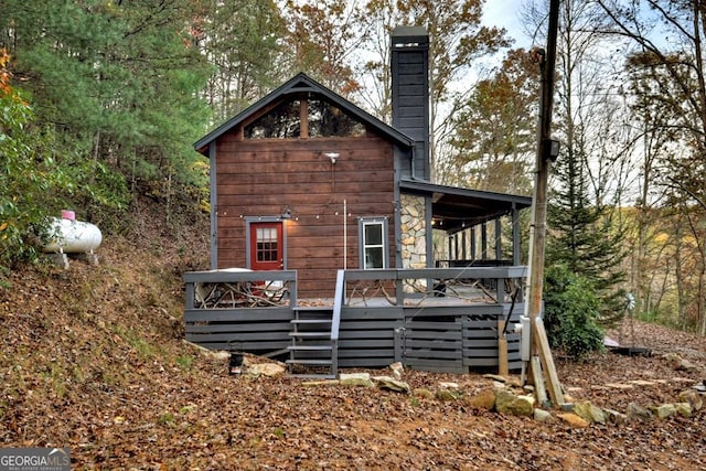 rear view of house with a chimney and a wooden deck