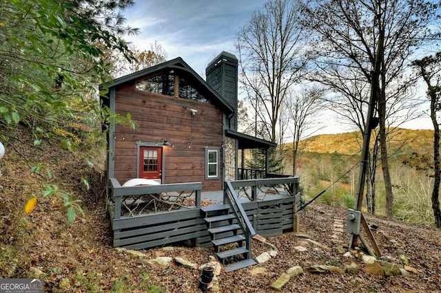 view of side of property with a deck and a chimney