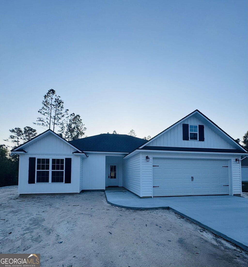 single story home featuring a garage, board and batten siding, and concrete driveway