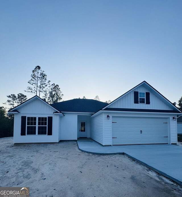single story home featuring a garage, board and batten siding, and concrete driveway