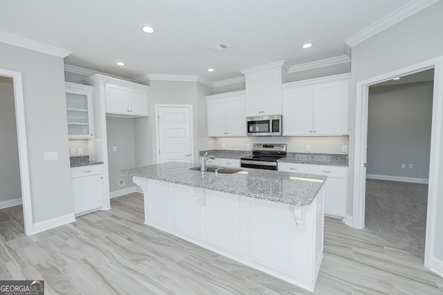 114 Richard Lee Dr, Kingsland, GA 31548 - kitchen with stainless steel appliances, white cabinets, a kitchen island with sink, light stone counters, and recessed lighting