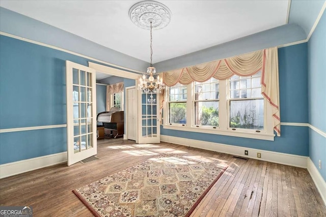 2265 E Lake Rd NE, Atlanta, GA 30307 - unfurnished dining area featuring baseboards, a chandelier, french doors, and wood-type flooring