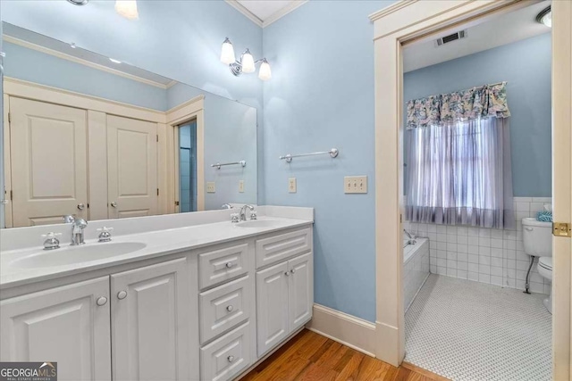2265 E Lake Rd NE, Atlanta, GA 30307 - bathroom featuring double vanity, wood finished floors, toilet, and a sink