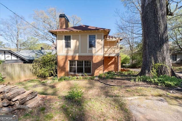 2265 E Lake Rd NE, Atlanta, GA 30307 - rear view of property featuring a balcony, a chimney, fence, and brick siding