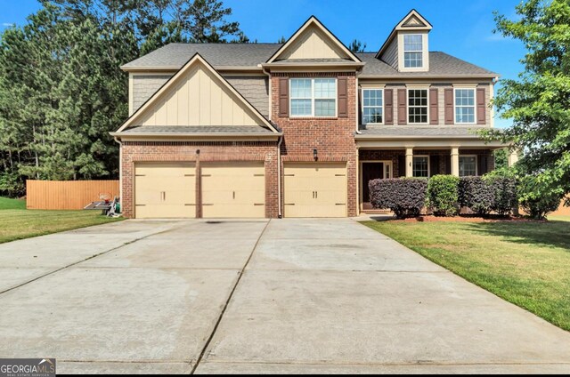 craftsman inspired home featuring fence, driveway, brick siding, and a front yard