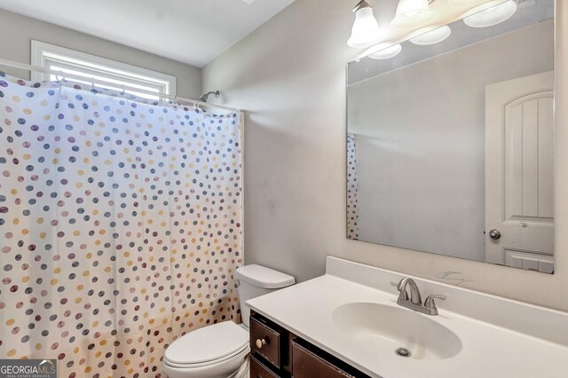 bathroom featuring a shower with curtain, vanity, and toilet