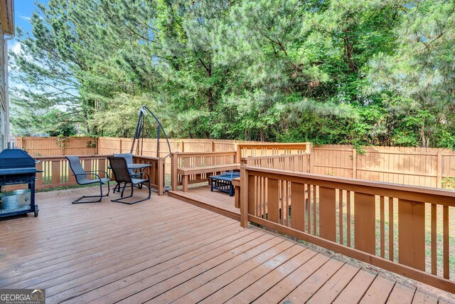 wooden deck with a fenced backyard, area for grilling, and outdoor dining space