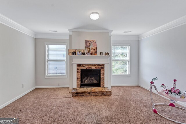 living room featuring carpet, ornamental molding, a fireplace, and a wealth of natural light