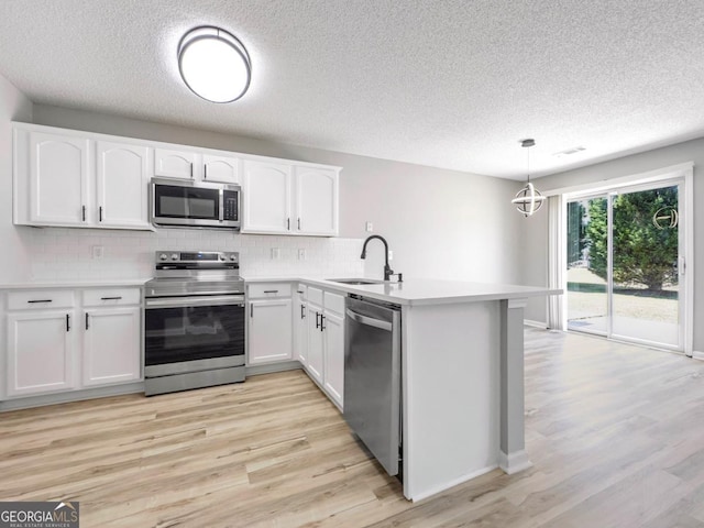 7229 Georges Way, Morrow, GA 30260 - kitchen featuring a peninsula, appliances with stainless steel finishes, white cabinetry, a sink, and backsplash