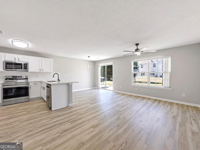 7229 Georges Way, Morrow, GA 30260 - kitchen featuring light countertops, a peninsula, stainless steel appliances, a sink, and open floor plan