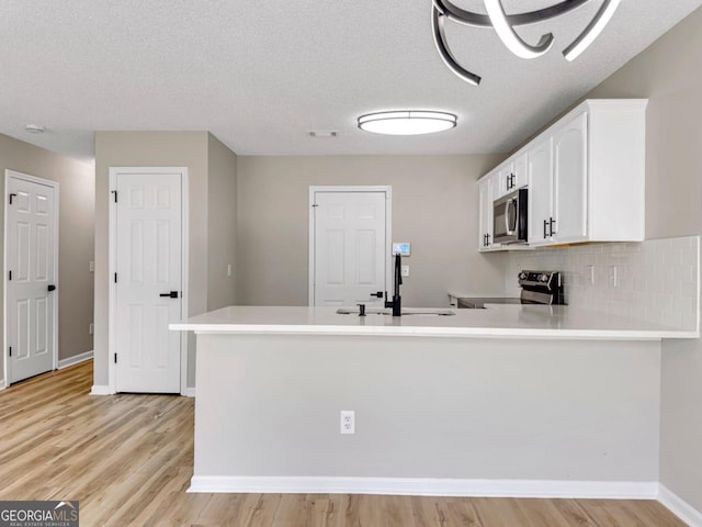 7229 Georges Way, Morrow, GA 30260 - kitchen with light countertops, a sink, a peninsula, and appliances with stainless steel finishes