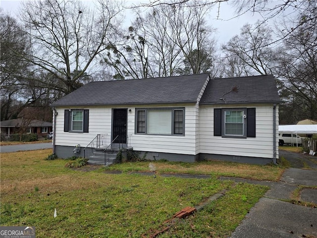 view of front of house featuring a front yard, crawl space, and a shingled roof