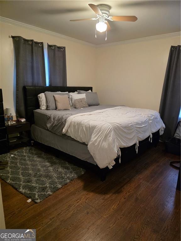 bedroom with crown molding, wood finished floors, and ceiling fan