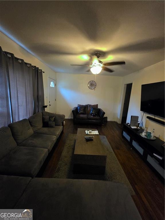 living room featuring baseboards, ceiling fan, and wood finished floors