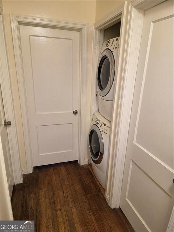 washroom with stacked washer and clothes dryer, dark wood-type flooring, and laundry area