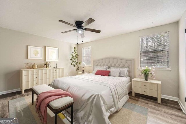 unfurnished room with baseboards, wood finished floors, and ceiling fan
