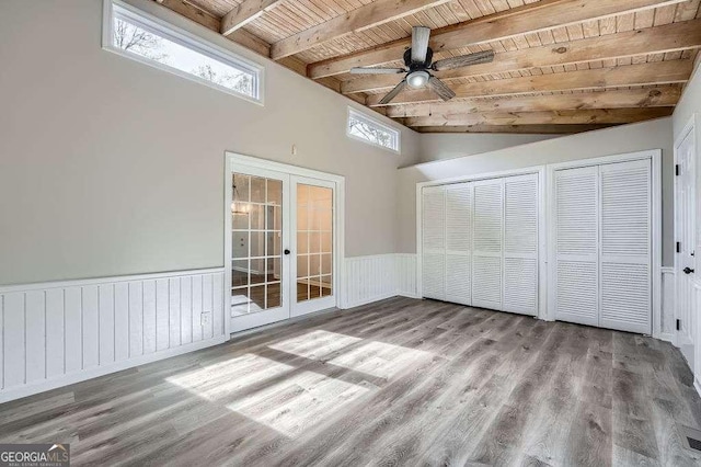foyer featuring lofted ceiling with beams, a wainscoted wall, ceiling fan, wood finished floors, and wood ceiling