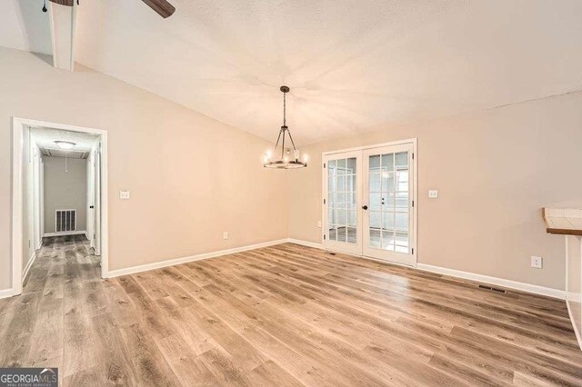 foyer entrance featuring visible vents, light wood-style floors, ceiling fan, and lofted ceiling with beams
