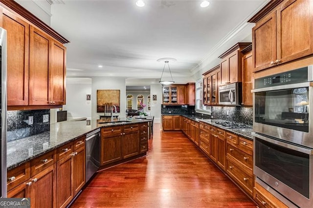 1109 Pine Grove Ave, Brookhaven, GA 30319 - kitchen featuring stainless steel appliances, ornamental molding, dark wood finished floors, dark stone countertops, and tasteful backsplash