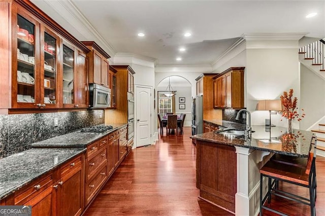 1109 Pine Grove Ave, Brookhaven, GA 30319 - kitchen featuring stainless steel appliances, dark wood-style flooring, glass insert cabinets, ornamental molding, and dark stone counters