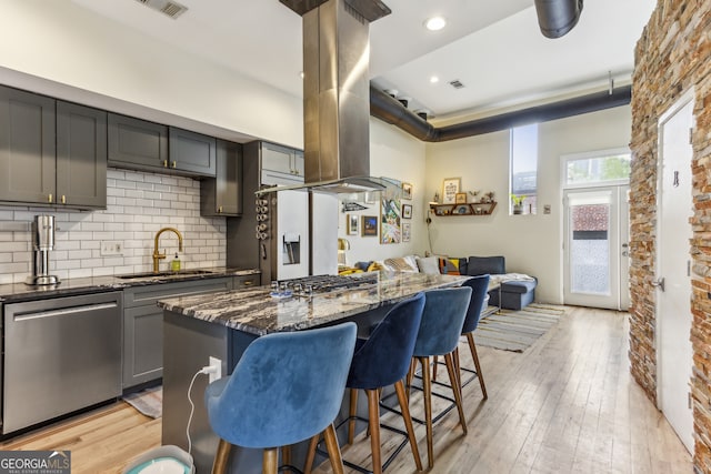 307 Cherokee Ave SE Unit 3, Atlanta, GA 30312 - kitchen featuring stainless steel appliances, dark stone countertops, a kitchen breakfast bar, island range hood, and tasteful backsplash