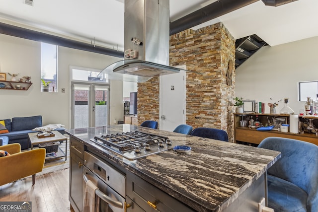 307 Cherokee Ave SE Unit 3, Atlanta, GA 30312 - kitchen featuring appliances with stainless steel finishes, island range hood, open floor plan, and dark stone counters