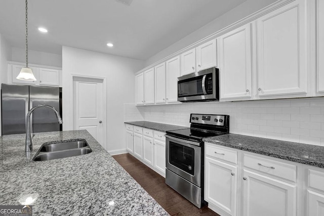 kitchen with dark wood-style flooring, white cabinetry, a sink, and appliances with stainless steel finishes
