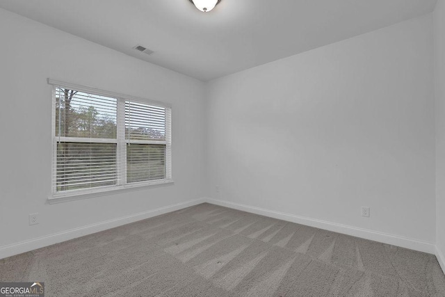 carpeted spare room with baseboards and visible vents