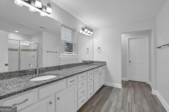 bathroom with visible vents, a sink, and a stall shower