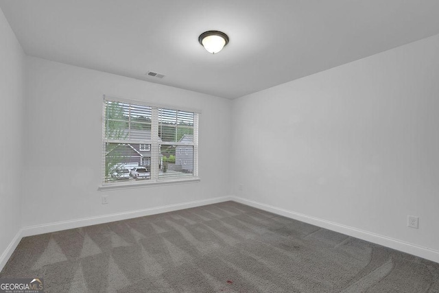 unfurnished room with visible vents, baseboards, and carpet flooring