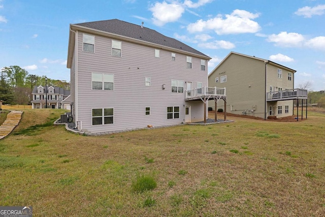back of property featuring a wooden deck, cooling unit, and a lawn