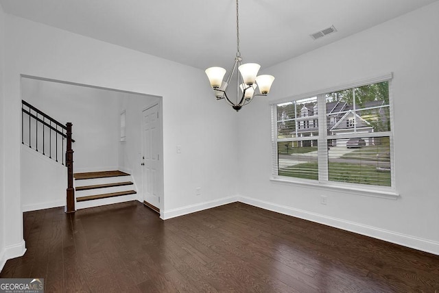 unfurnished dining area with a notable chandelier, baseboards, stairway, dark wood-type flooring, and visible vents