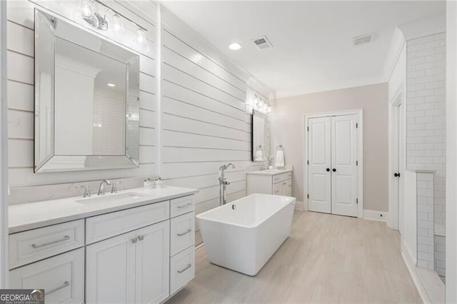 557 Stone Field Run NW, Marietta, GA 30060 - full bathroom featuring visible vents, ornamental molding, wood finished floors, two vanities, and a sink