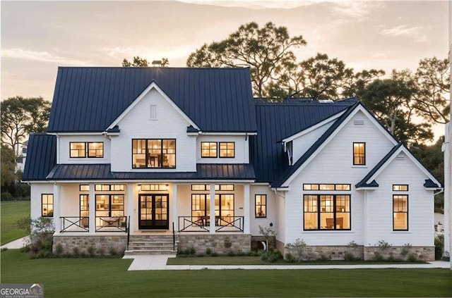152 Sherwood Ln, Canton, GA 30115 - back of house at dusk with metal roof, covered porch, a standing seam roof, and french doors