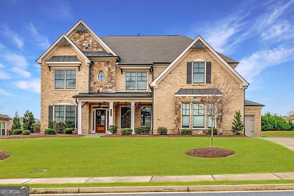 4720 Gablestone Xing, Hoschton, GA 30548 - craftsman house featuring a front lawn, an attached garage, and brick siding