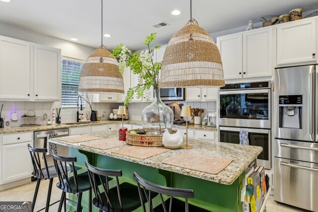 5225 Tye Trl, Fairburn, GA 30213 - kitchen with appliances with stainless steel finishes, backsplash, white cabinetry, a kitchen island, and recessed lighting