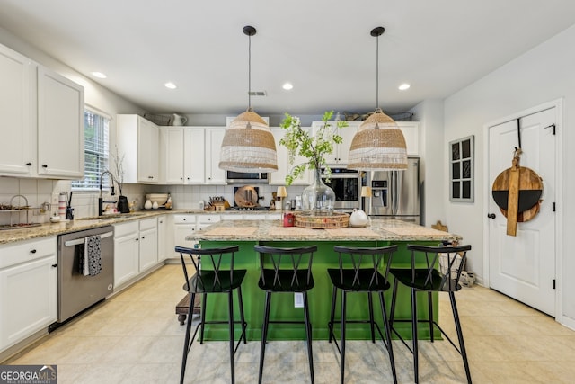 5225 Tye Trl, Fairburn, GA 30213 - kitchen featuring appliances with stainless steel finishes, a sink, backsplash, a kitchen island, and white cabinets