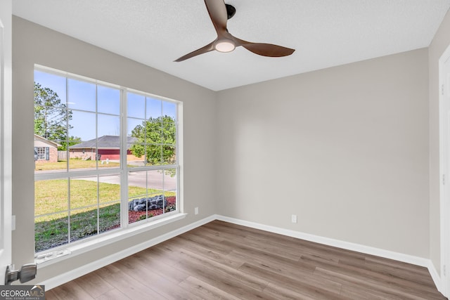 unfurnished room featuring wood finished floors, baseboards, and ceiling fan