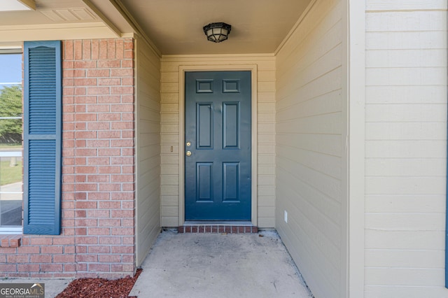 view of exterior entry with brick siding