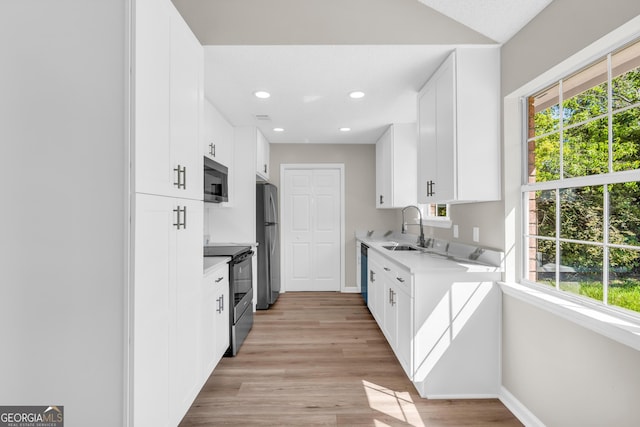 kitchen with light countertops, baseboards, stainless steel appliances, and a sink