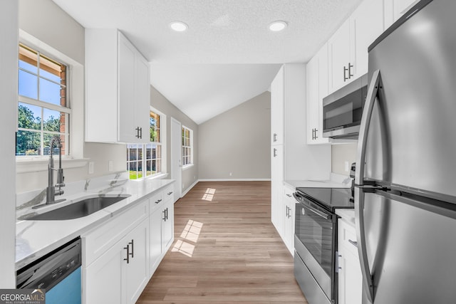 kitchen with plenty of natural light, a textured ceiling, appliances with stainless steel finishes, and a sink