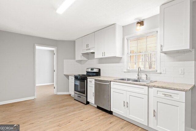 140 Elberta Dr, Newnan, GA 30265 - kitchen featuring appliances with stainless steel finishes, a sink, under cabinet range hood, white cabinetry, and backsplash