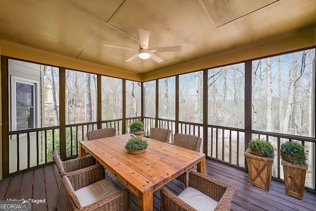 sunroom / solarium featuring a ceiling fan and outdoor dining area