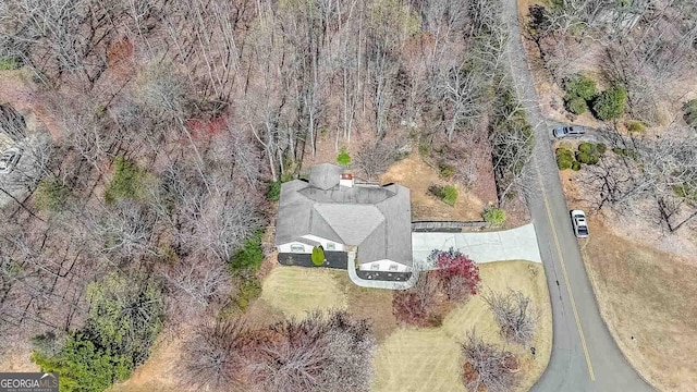 aerial view of property and surrounding area with a heavily wooded area