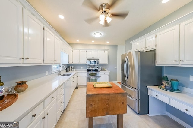 kitchen with stainless steel appliances, a sink, white cabinets, a ceiling fan, and recessed lighting
