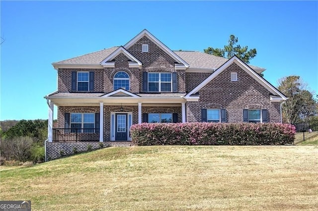 craftsman inspired home featuring brick siding, a porch, and a front lawn